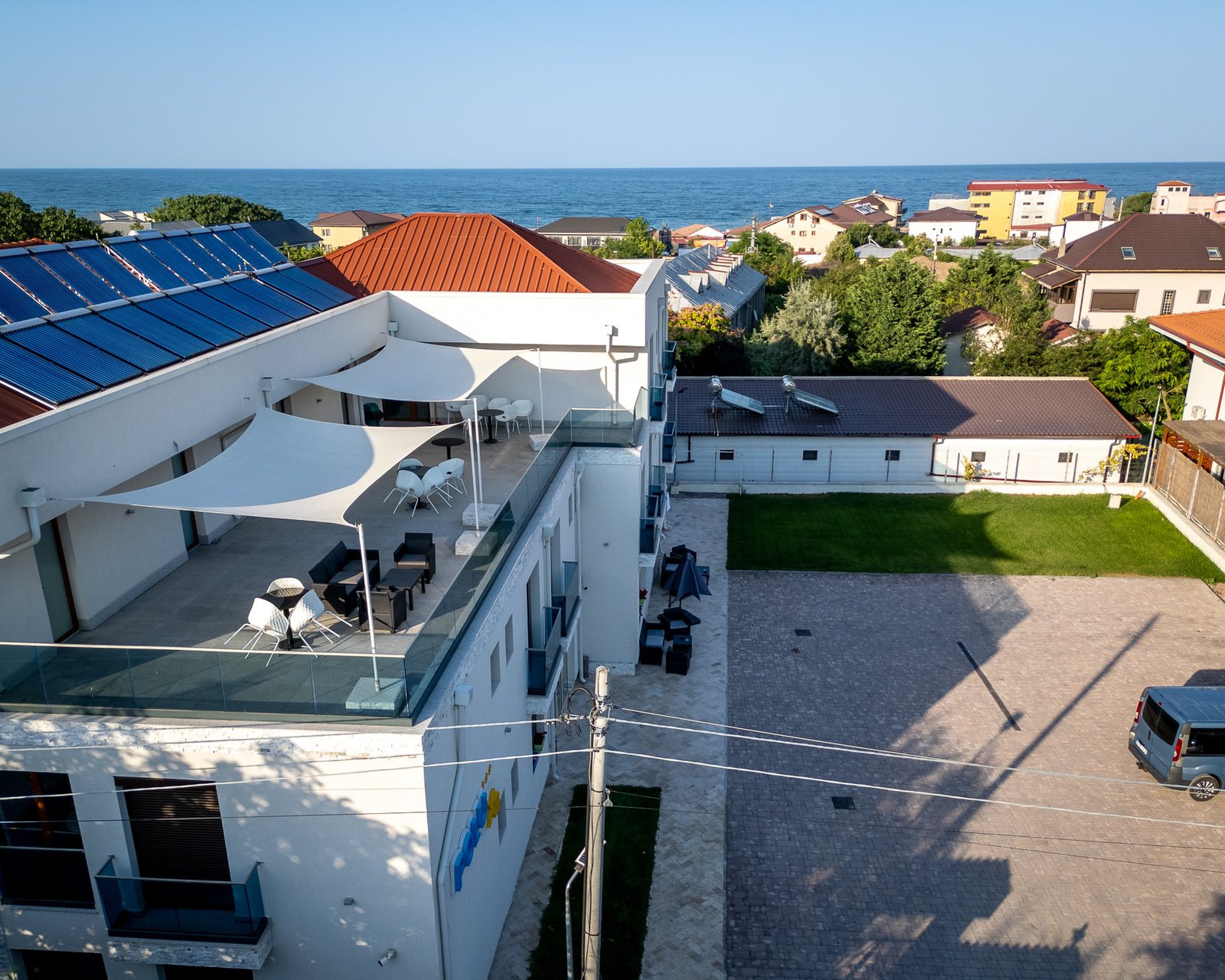 Clădire albă cu terasă, vedere către mare